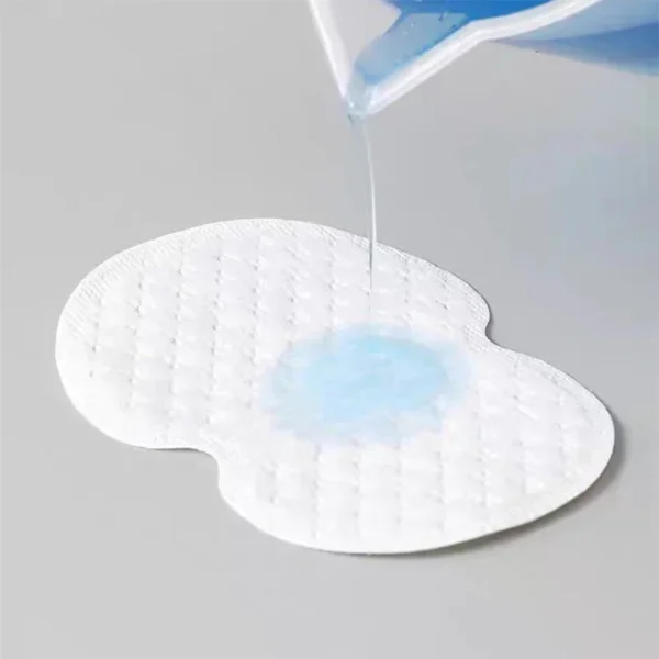 Gros plan sur un coussinet anti-transpiration adhésif fin et discret collé à l'intérieur d'une chemise blanche, illustrant son invisibilité sous le tissu. 👕💧